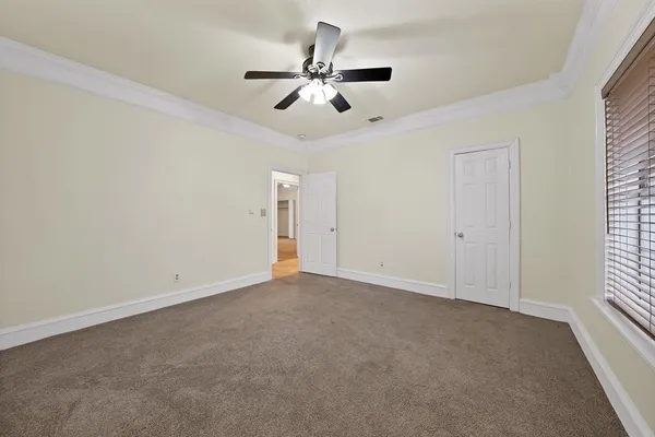 an empty room with fan and windows