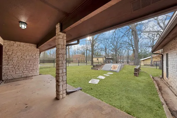 a view of a backyard with table and chairs under a large tree