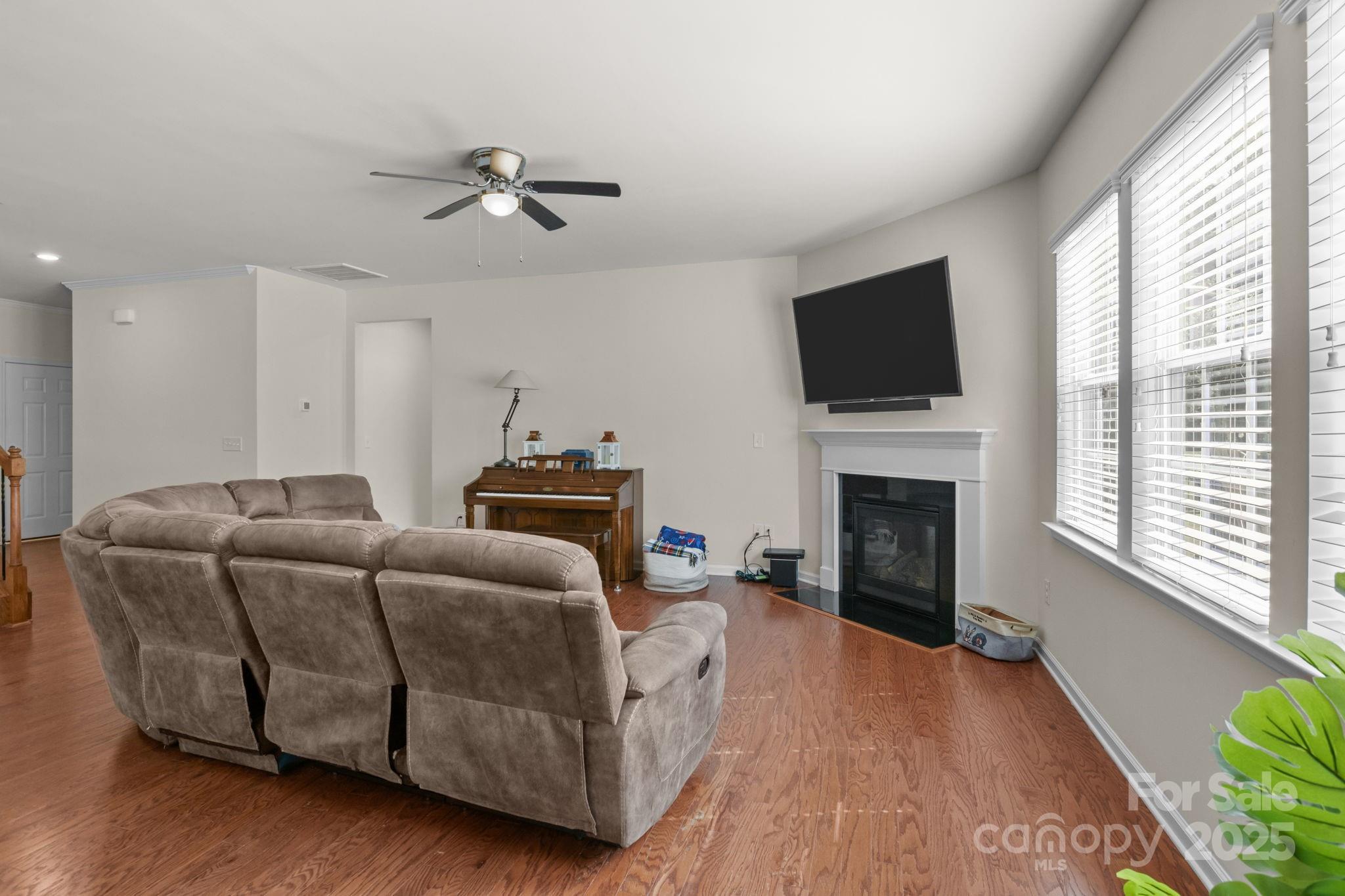 15925 Foreleigh Road Huntersville, NC 28078 - Photo 9 of 48 a living room with furniture a fireplace and a flat screen tv