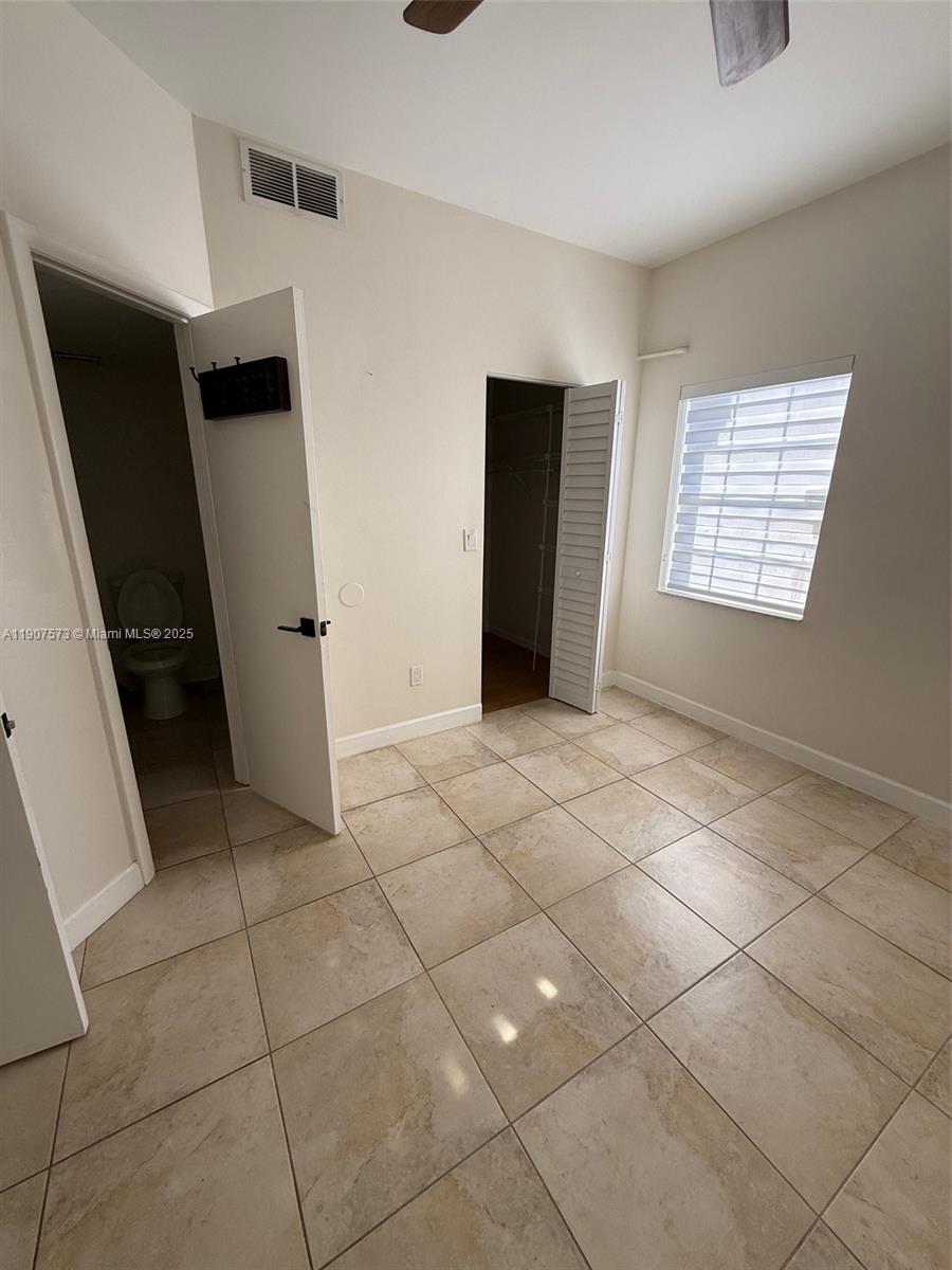 18308 Northwest 68th Avenue, Unit F Hialeah, FL 33015 - Photo 9 of 17 wooden floor in an empty room with a window