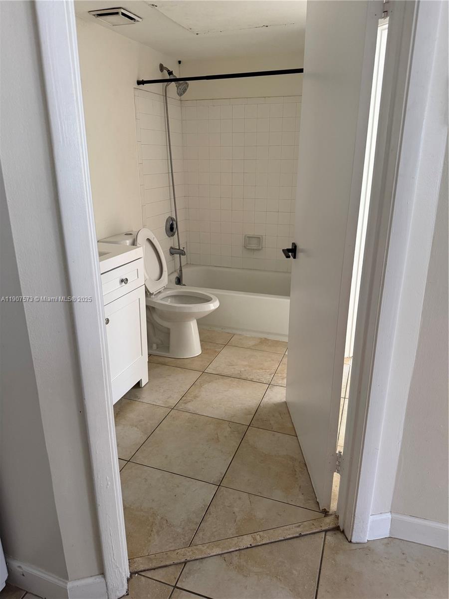 18308 Northwest 68th Avenue, Unit F Hialeah, FL 33015 - Photo 10 of 17 a bathroom with a granite countertop sink toilet and shower