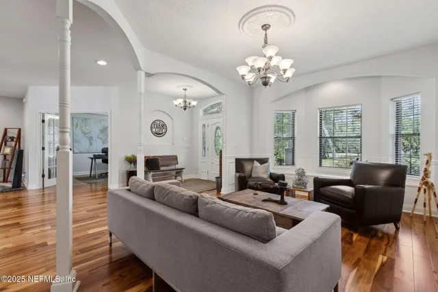 a work room with furniture a large window and a chandelier