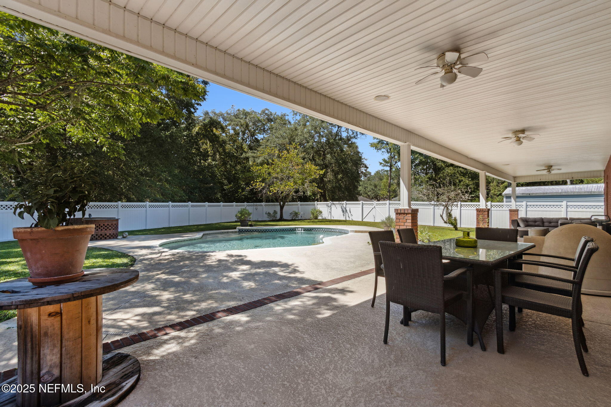 87377 Raddin Road Yulee, FL 32097 - Photo 63 of 75 a view of a patio with table and chairs and potted plants