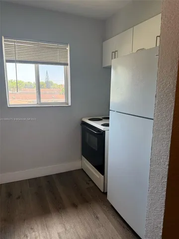 a white refrigerator freezer and a stove sitting inside of a kitchen