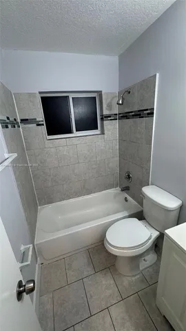 a white toilet sitting next to a bath tub