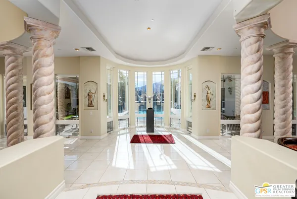 a living room with patio furniture and a chandelier
