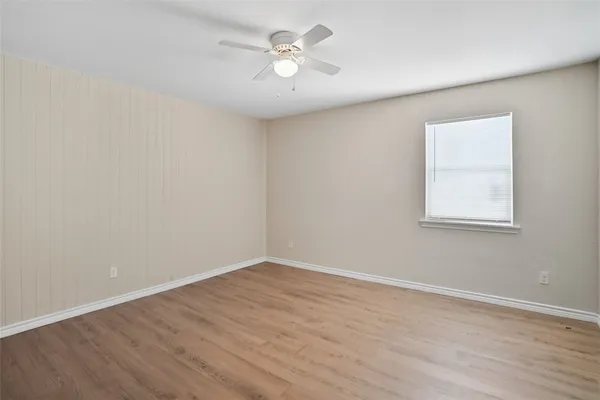 a view of a room with wooden floor and a ceiling fan