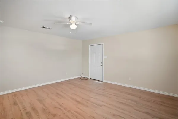 a view of an empty room with wooden floor