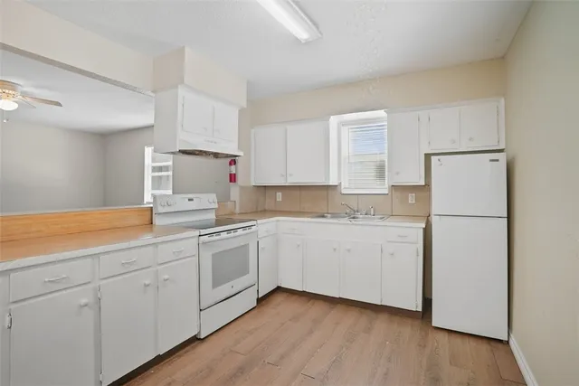 a kitchen with sink cabinets and wooden floor