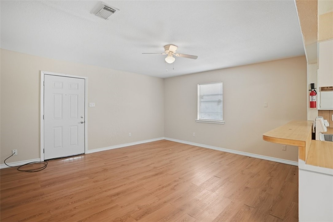 868 Gonzales Street, Unit 2 Robstown, TX 78380 - Photo 10 of 16 wooden floor in an empty room with a window