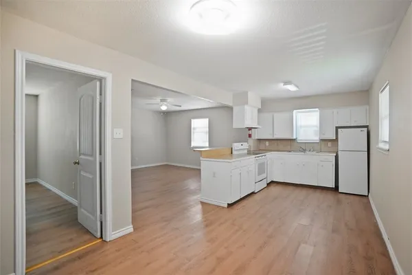 a kitchen with white cabinets and white appliances