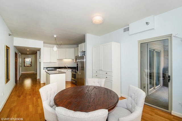 720 West Randolph Street, Unit 808 Chicago, IL 60661 - Photo 4 of 15 a living room with stainless steel appliances furniture a rug and a kitchen