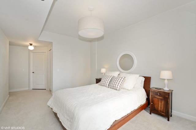 720 West Randolph Street, Unit 808 Chicago, IL 60661 - Photo 9 of 15 a bedroom with a bed and a lamp