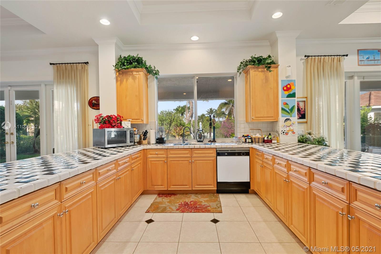 2920 Luckie Road Weston, FL 33331 - Photo 45 of 60 a large kitchen with kitchen island granite countertop a sink and white cabinets