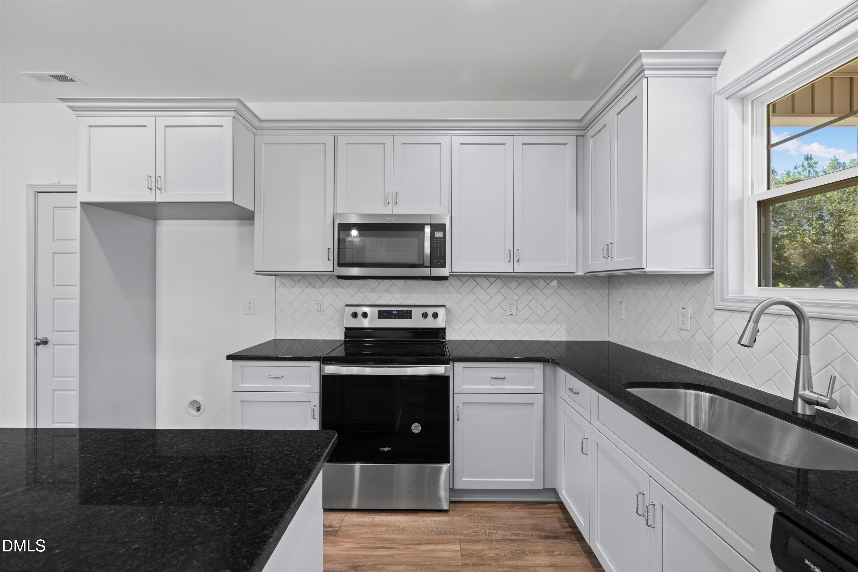 73 Falls Riv Court Broadway, NC 27505 - Photo 24 of 39 a kitchen with granite countertop white cabinets stainless steel appliances and a sink