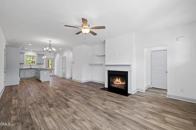a view of an empty room with a fireplace and a window