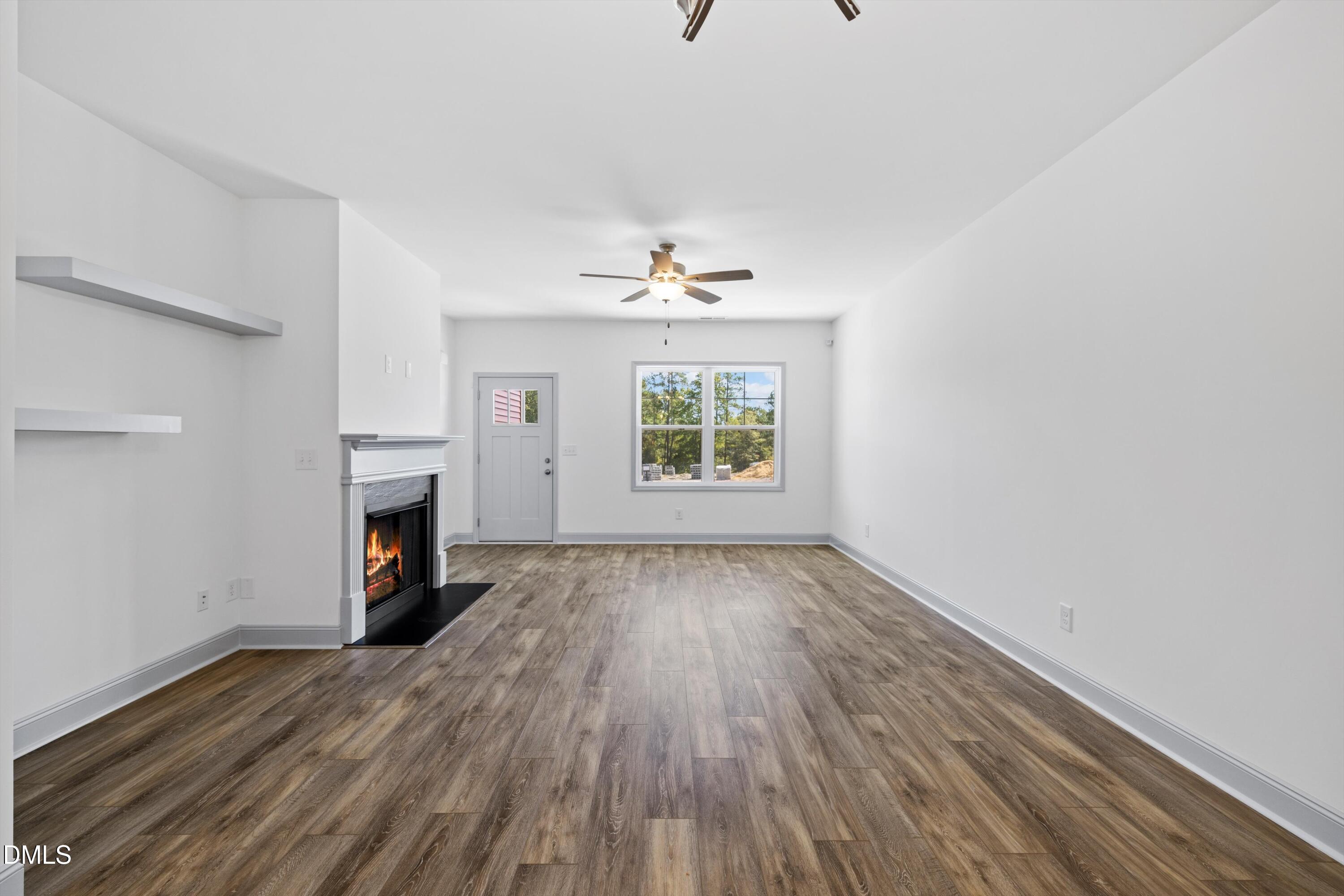 73 Falls Riv Court Broadway, NC 27505 - Photo 10 of 39 an empty room with windows fireplace and wooden floor