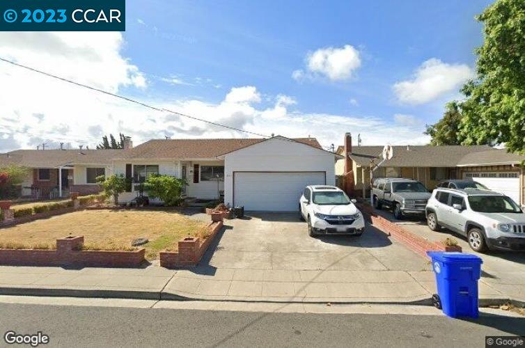 a front view of a house with cars parked