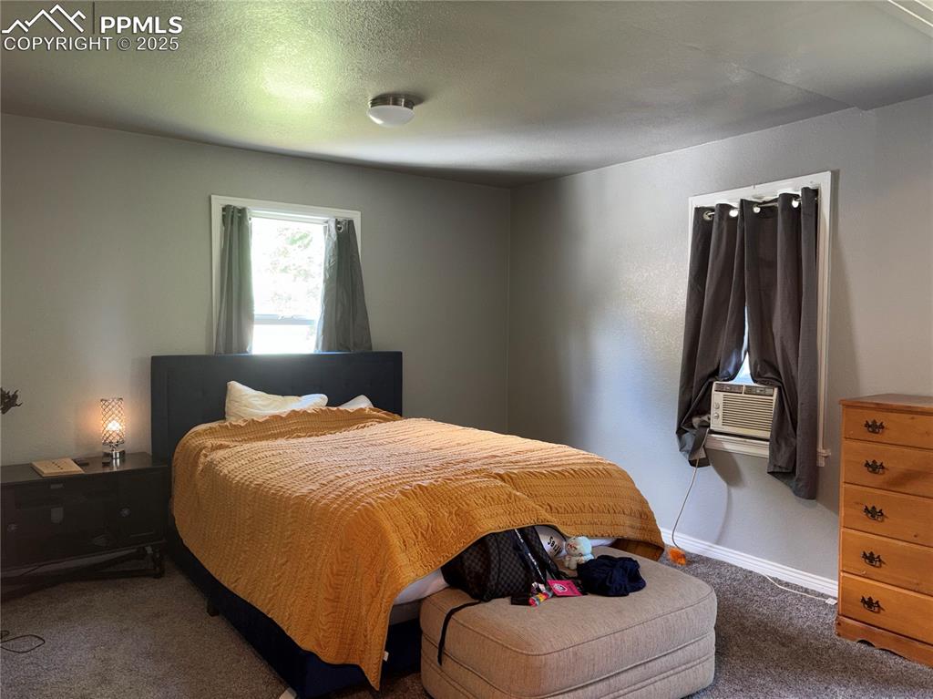 2453 East Willamette Avenue, Unit 1/2 Colorado Springs, CO 80909 - Photo 12 of 16 a bedroom with a bed and a dresser