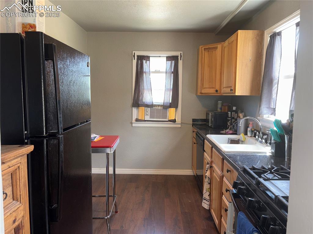 2453 East Willamette Avenue, Unit 1/2 Colorado Springs, CO 80909 - Photo 7 of 16 a kitchen with stainless steel appliances granite countertop a sink stove and refrigerator