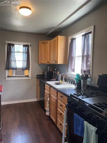 a kitchen with a stove a sink and a window