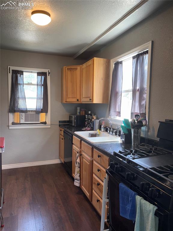 2453 East Willamette Avenue, Unit 1/2 Colorado Springs, CO 80909 - Photo 8 of 16 a kitchen with a stove a sink and a window