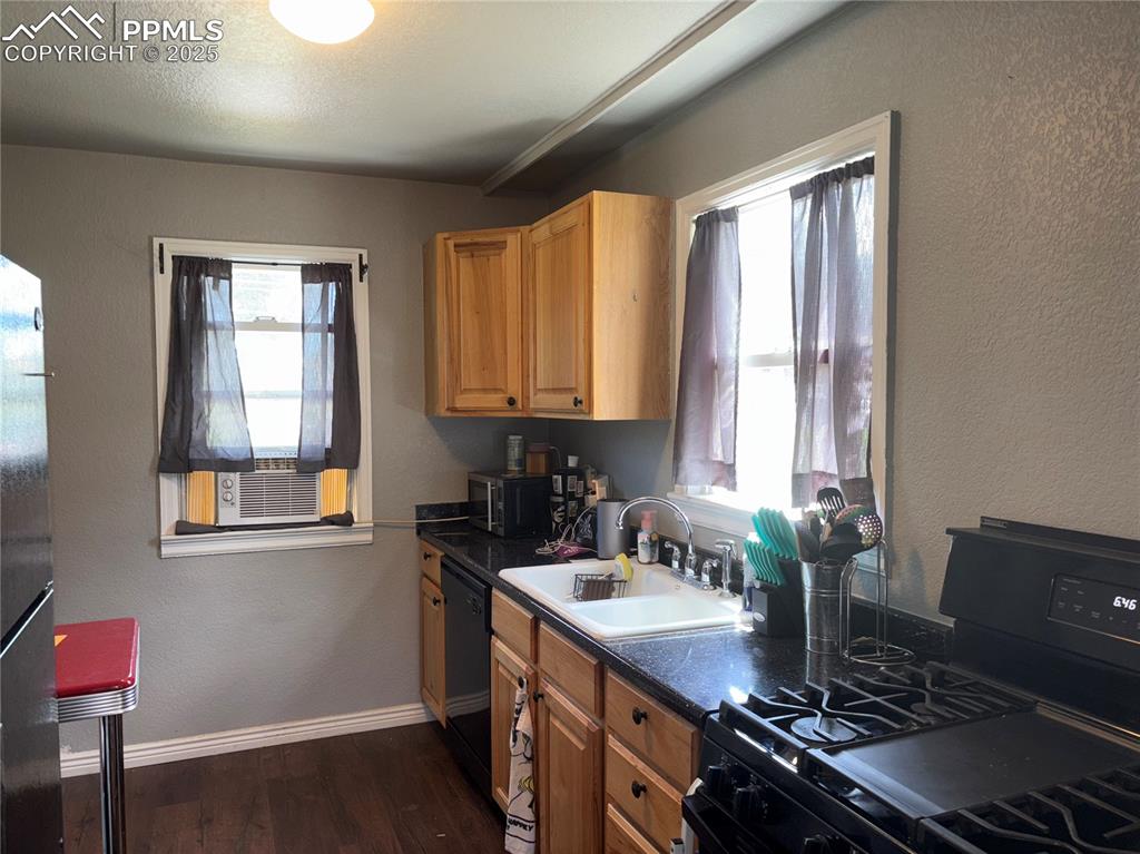 2453 East Willamette Avenue, Unit 1/2 Colorado Springs, CO 80909 - Photo 9 of 16 a kitchen with a sink stove top oven and cabinets