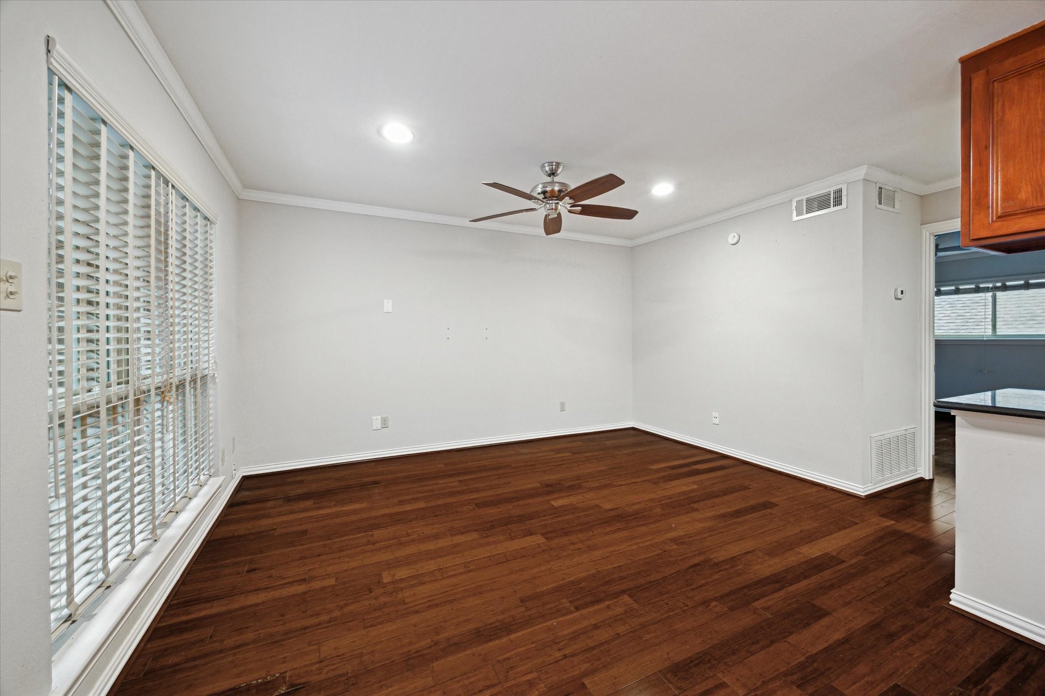 611 Hawthorne Street, Unit 5 Houston, TX 77006 - Photo 5 of 10 a view of a room with wooden floor a ceiling fan and windows