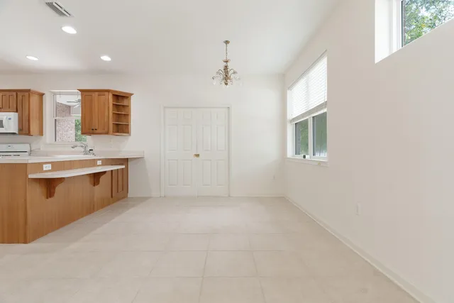 an empty room with windows and ceiling fan