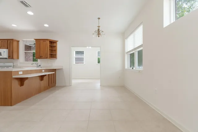 a view of an empty room and chandelier fan