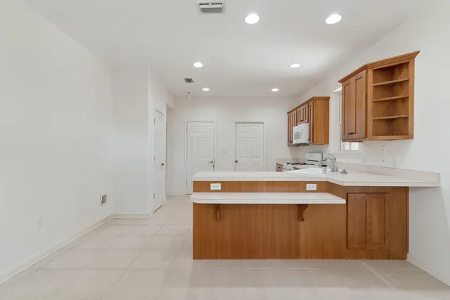 a kitchen with stainless steel appliances granite countertop a sink and a refrigerator