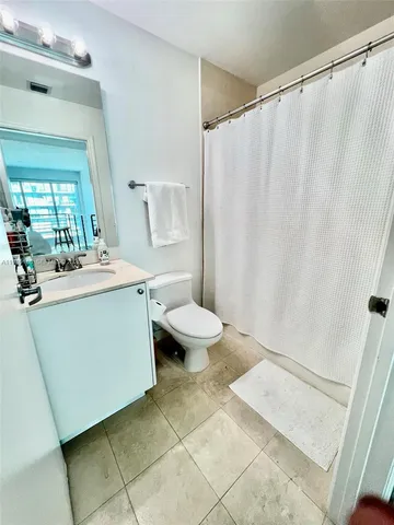 a room with a sink a toilet and a mirror