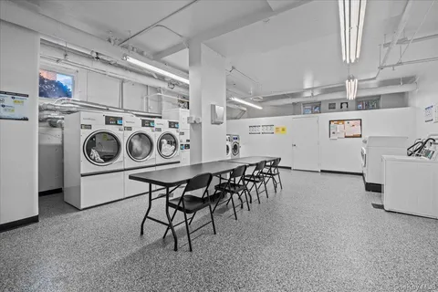 a utility room with dryer washer and stair