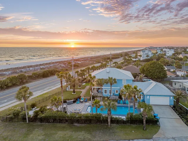 a front view of a building with garden and trees