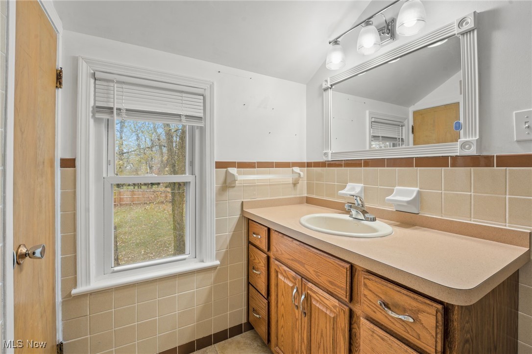 5232 East Farnhurst Road Cleveland, OH 44124 - Photo 24 of 28 Bathroom with lofted ceiling, a wealth of natural light, vanity, and tile walls