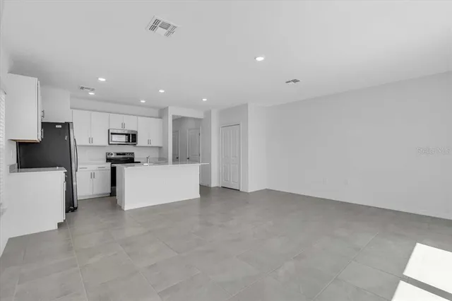 a view of kitchen with white cabinets and stainless steel appliances