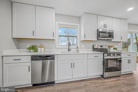a kitchen with granite countertop a sink stainless steel appliances and cabinets