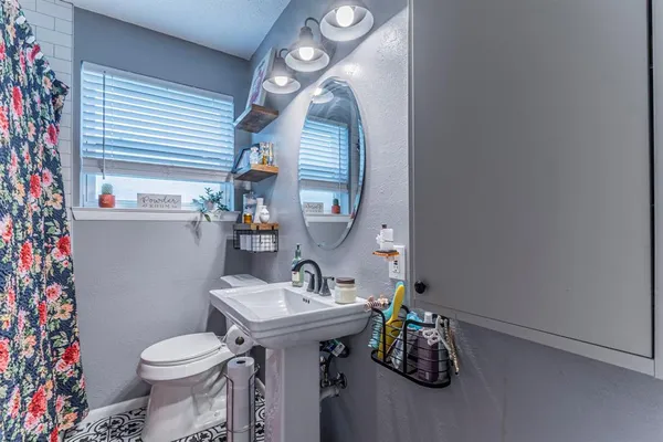 a bathroom with a sink toilet and mirror