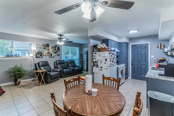 a living room with furniture a dining table and a chandelier