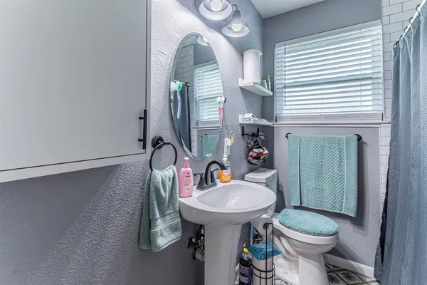 a bathroom with a sink a toilet and mirror
