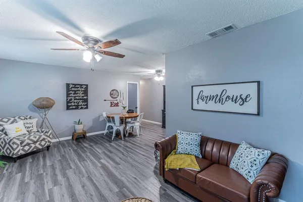 a living room with furniture and wooden floor