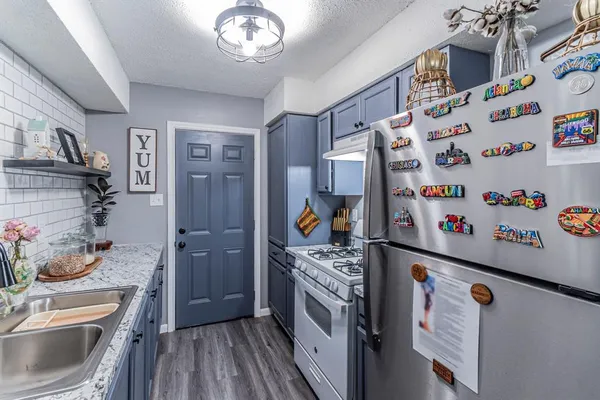 a kitchen with stainless steel appliances a stove a sink and a refrigerator