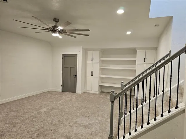 a view of an empty room with a chandelier fan