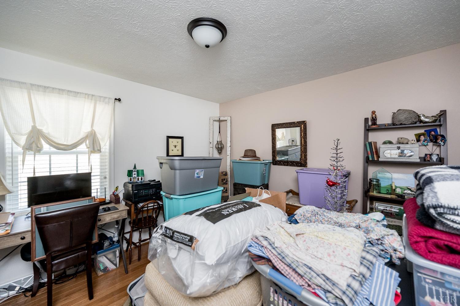 375 East Perch Road Monroe, VA 24574 - Photo 21 of 73 a bed room with a bed a television and a chair