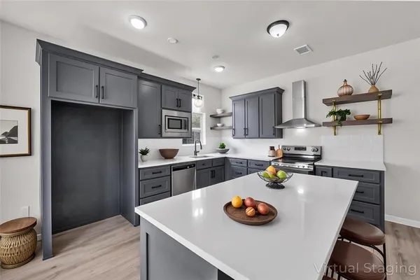 a kitchen with stainless steel appliances granite countertop a sink dishwasher stove and refrigerator with wooden floor