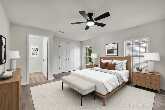 a bedroom with a bed a mirror on dresser and a window