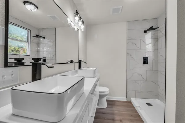 a bathroom with a sink a toilet and shower