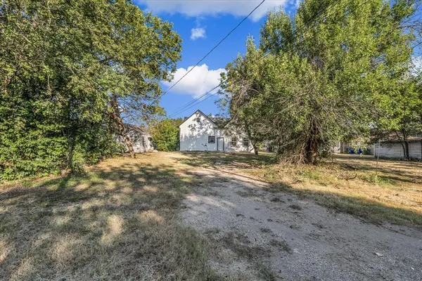 a view of dirt yard with a tree
