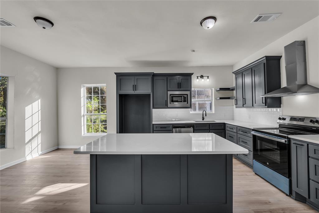 2524 McFerrin Avenue Waco, TX 76708 - Photo 8 of 29 a large kitchen with stainless steel appliances a large counter top stove and refrigerator