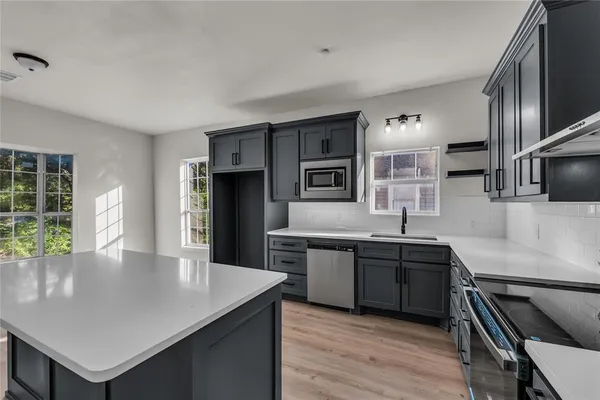 a kitchen with stainless steel appliances granite countertop a sink counter space and cabinets